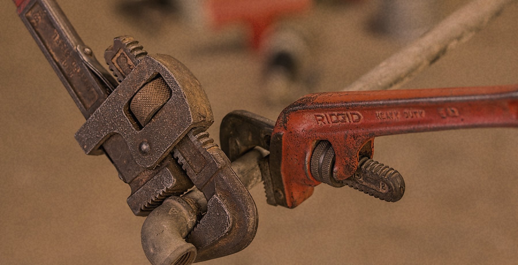A pipe wrench tightening a plumbing fitting